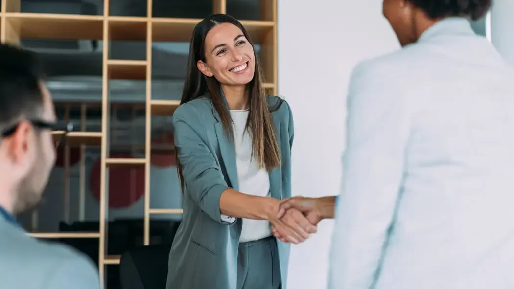 Two women in smart clothing shaking hands