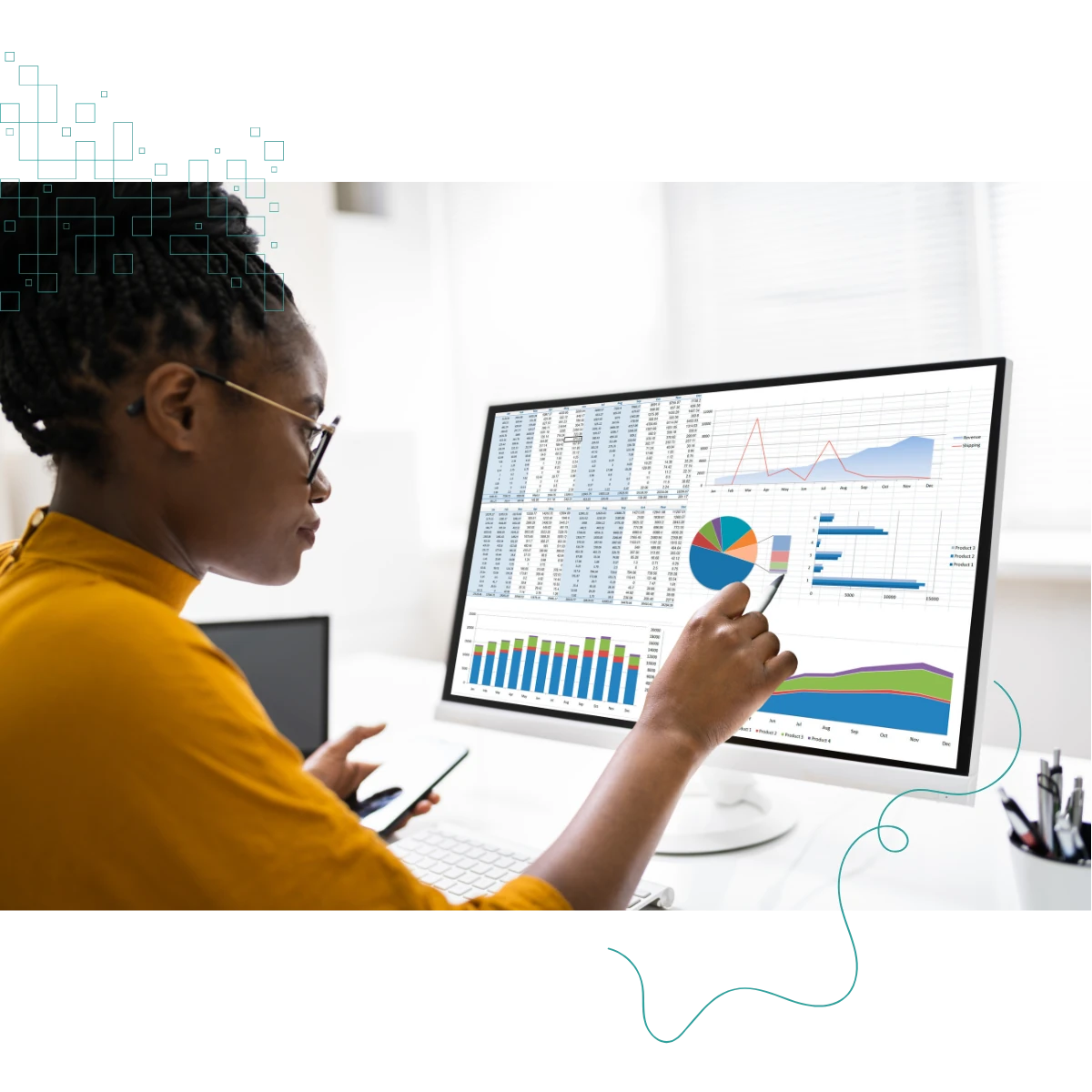 Black woman say at a desk in front of a computer screen displaying tables and charts